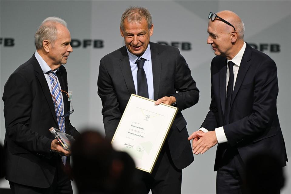 Bernard Dietz (l) wird von Jürgen Klinsmann und DFB-Präsident Bernd Neuendorf für die Ernennung zum Ehrenspielführer gratuliert.Arne Dedert/dpa