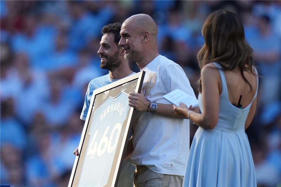 Bernardo Silva (l) und Trainer Pep Guardiola während einer Zeremonie nach ihrem letzten Spiel für Manchester City.Alastair Grant/AP/dpa