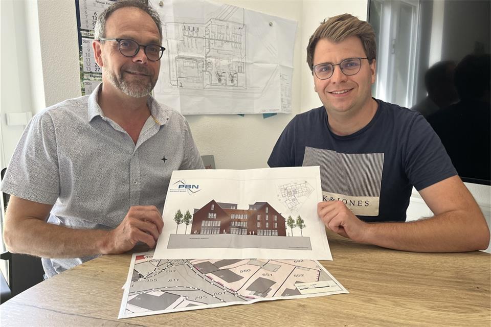Bernd und Frank Nienhaus (r.) zeigen den vom Architekten Reinhold Eversmann gezeichneten Entwurf des Neubaus.