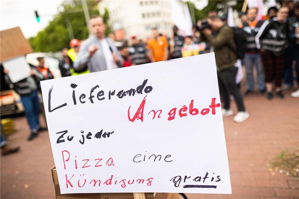 Beschäftigte des Essenslieferdienstes Lieferando nehmen an einer Kundgebung auf dem Weißekreuzplatz teil. Lieferando plant, den Lieferbetrieb in einigen Städten einzustellen.Moritz Frankenberg/dpa