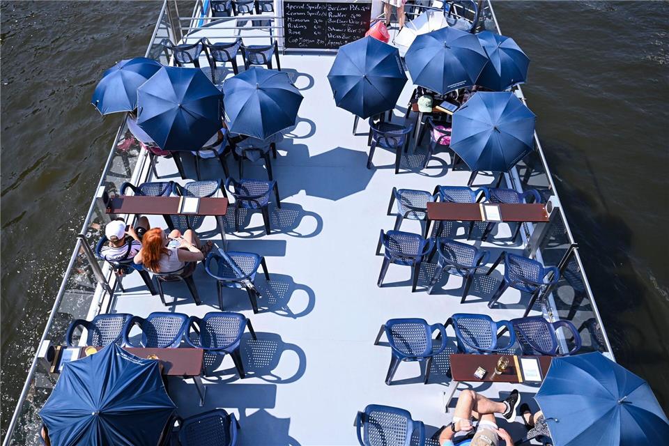 Bilder des Tages Beschirmt gegen die Sonne - Touristen auf der SpreeKatharina Kausche/dpa