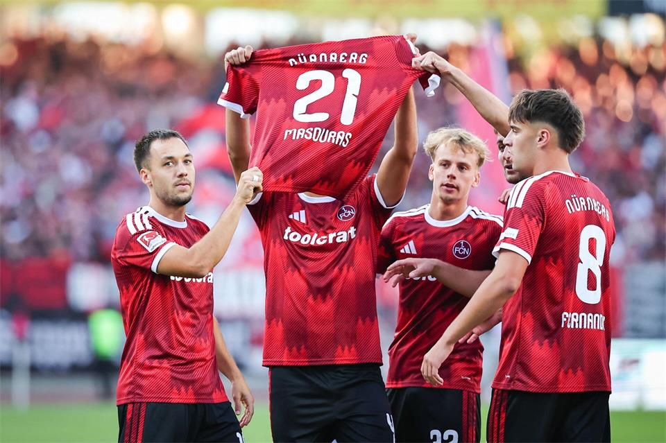 Besonderer Torjubel: Nach dem 1:0 halten Nürnbergs Profis das Trikot des fehlenden Kollegen Ioannis Masouras in die Höhe. Daniel Karmann/dpa