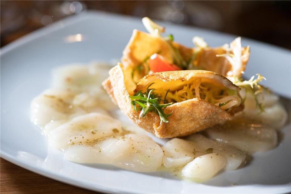 Besonders edel schmeckt ein Carpaccio aus Jakobsmuscheln als Vorspeise. Dafür werden pro Esser drei Nüsse kalkuliert. Jede davon wird horizontal in vier dünne Scheiben geschnitten. Alle zusammen werden auf dem Teller rund um weitere Zutaten zu einer Rosette drapiert. picture alliance / dpa Themendienst