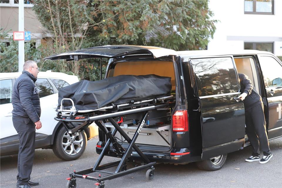 Bestatter laden eine Leiche in einen Leichenwagen.Sascha Thelen/dpa