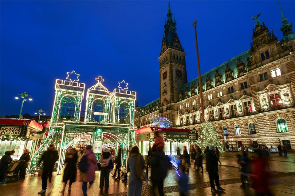 Besucher laufen zum Weihnachtsmarkt in der Innenstadt. Christian Charisius/dpa