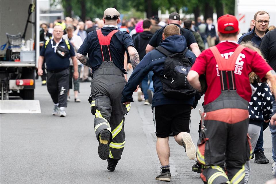 Besucher rennen zu Messebeginn auf der Messe Interschutz, um in Halle 15 einen von 1.000 kostenlosen Rucksäcken am Stand von Haix zu ergattern.Julian Stratenschulte/dpa
