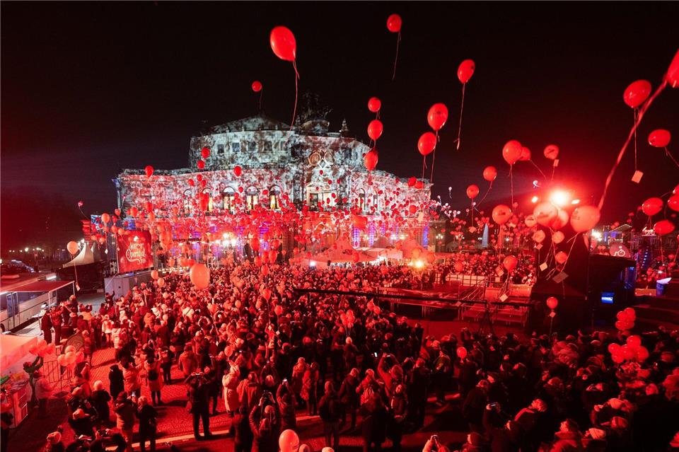 Besucher und Schaulustige lassen auf dem Theaterplatz rote Luftballons steigen.Sebastian Kahnert/dpa