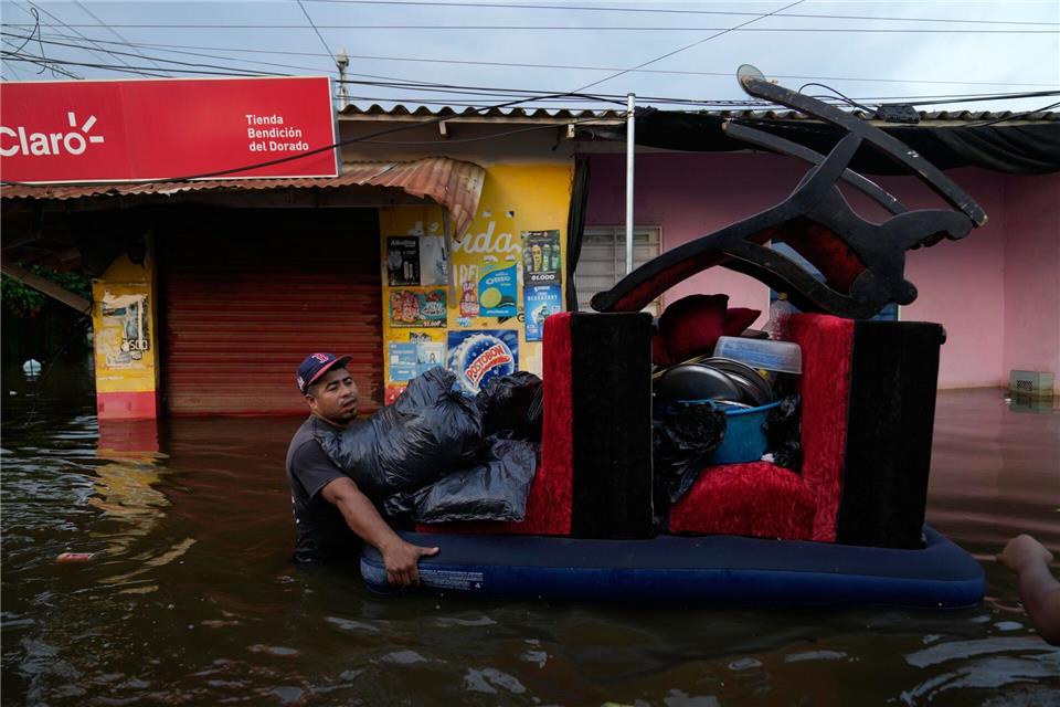 Bewohner bergen Hab und Gut aus überfluteten Häusern in der kolumbianischen Stadt Monteria, nachdem der Fluss Sinu durch Regen über die Ufer getreten ist.Fernando Vergara/AP/dpa