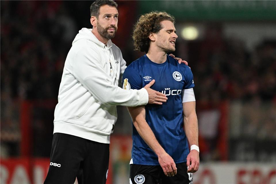 Bielefelds-Trainer Kniat tröstet seinen Spieler Corboz (r.)Soeren Stache/dpa