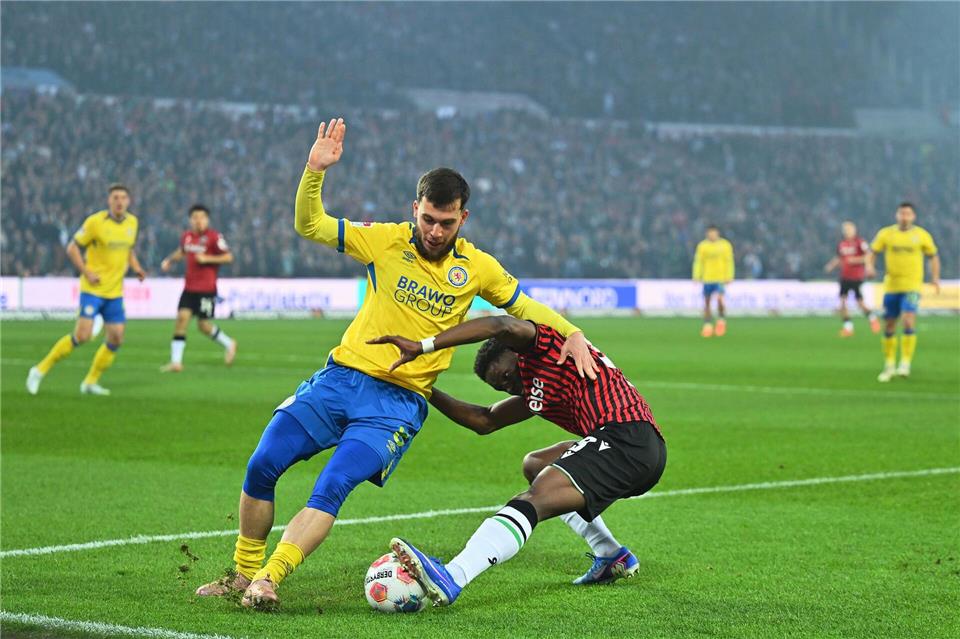 Braunschweigs Mehmet Aydin und William Kokolo von Hannover 96 im Zweikampf. Swen Pförtner/dpa