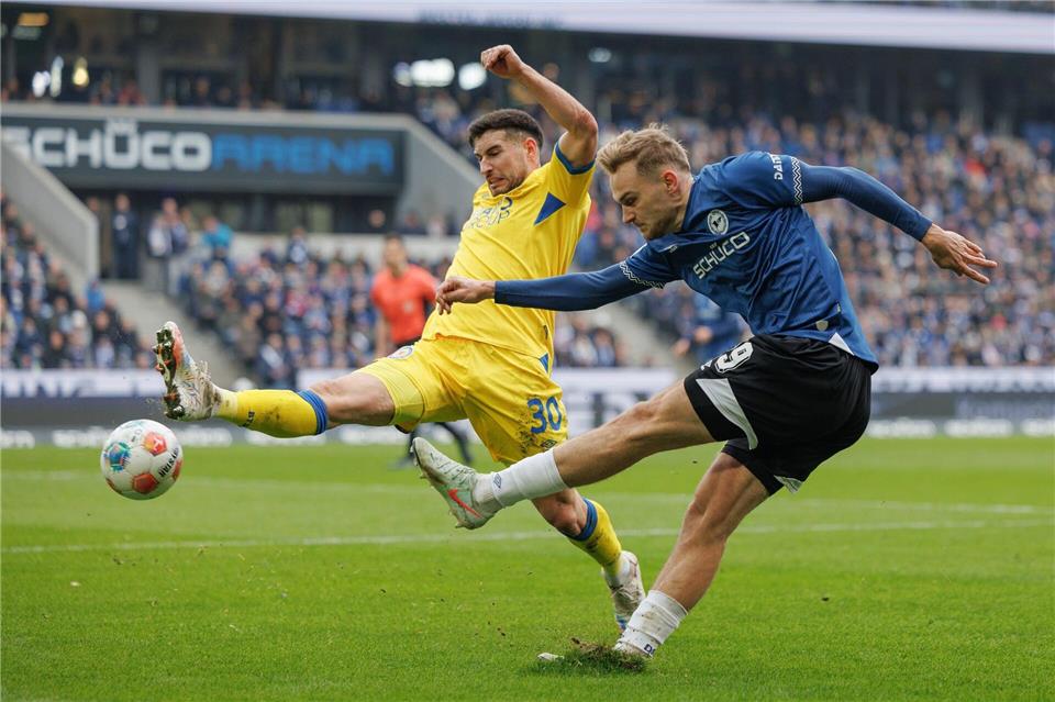 Braunschweigs Robin Heußer im Kampf um den Ball mit Bielefelds Tim Handwerker. Friso Gentsch/dpa
