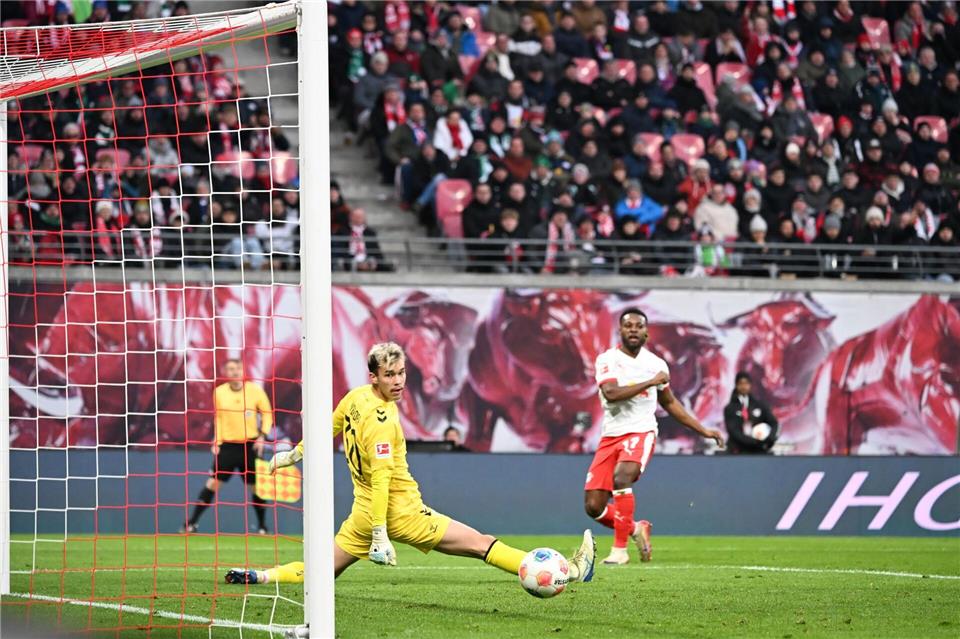 Bremens Torwart Mio Backhaus (l, Werder Bremen) und Ridle Baku (RB Leipzig) schauen dem Ball hinterher. Backhaus verhinderte mit seinen Paraden einen frühen Rückstand der Gäste in Leipzig.Jennifer Brückner/dpa