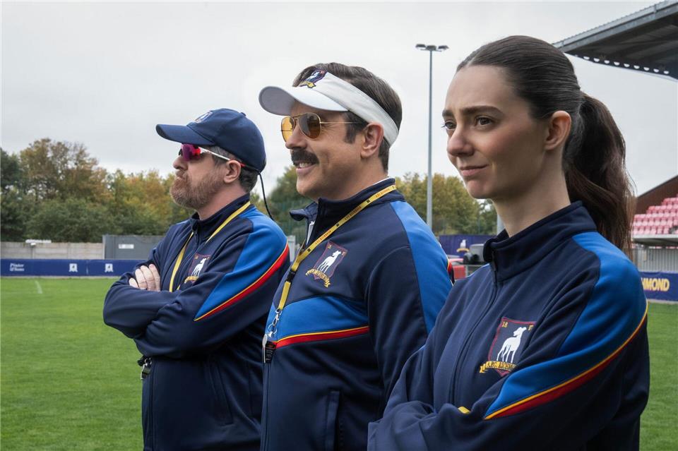 Brendan Hunt, Jason Sudeikis und Tanya Reynolds in einer Szene der Serie „Ted Lasso“ - die 4. Staffel kommt jetzt bei Apple TV (ab 5. August).-/Apple TV/dpa
