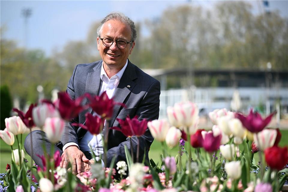 Bürgermeister Reiner Breuer (SPD) sitzt auf dem Gelände der Landesgartenschau zwischen den Blumen. Federico Gambarini/dpa