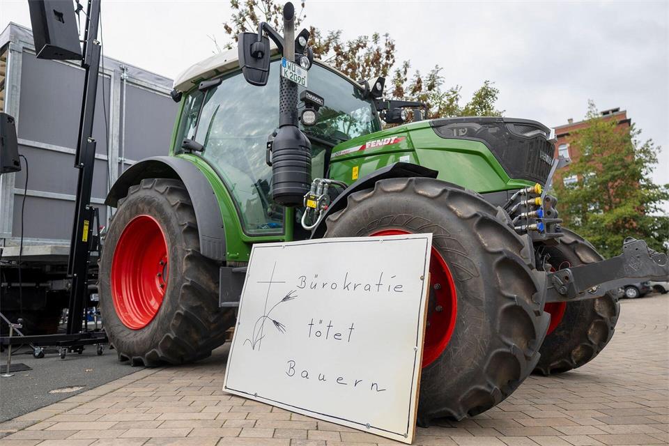 „Bürokratie tötet Bauern“ steht auf einem Schild vor einem Traktor bei einer Kundgebung am Rande der Agrarministerkonferenz.Heiko Becker/dpa