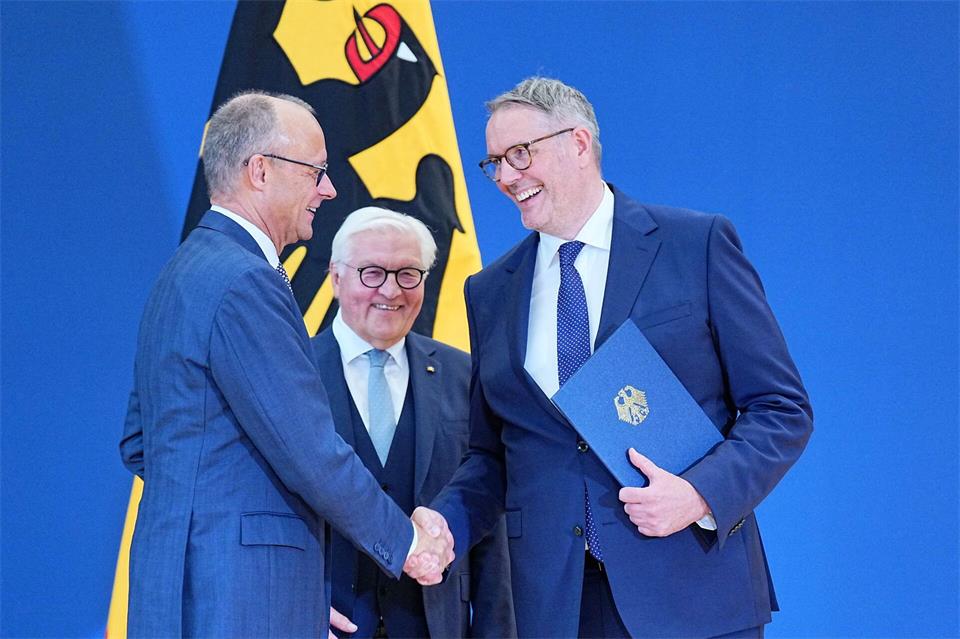 Bundeskanzler Friedrich Merz (CDU) gratuliert Alexander Schweitzer (SPD) nach seiner Ernennung zum neuen Arbeitsminister durch Bundespräsident Frank-Walter Steinmeier. Michael Kappeler/dpa
