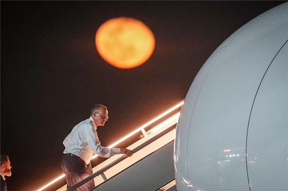 Bundeskanzler Friedrich Merz geht die Gangway vor dem aufgehenden Mond hinauf.Kay Nietfeld/dpa