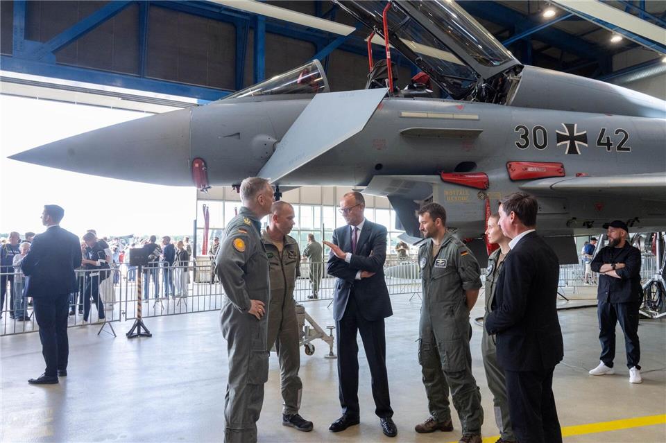 Bundeskanzler Merz unterhielt sich im Hangar vor einem Eurofighter mit Soldaten.Stefan Sauer/dpa