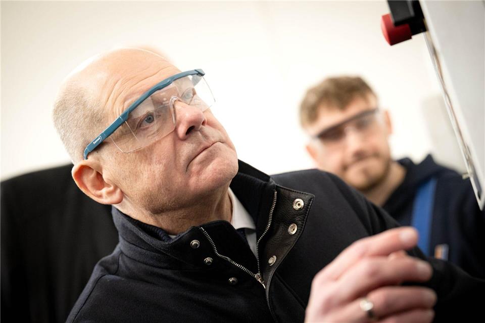 Bundeskanzler Olaf Scholz (SPD, l.), Spitzenkandidat seiner Partei für die Bundestagswahl, hat sich bei einem Besuch der Lloyd Werft in Bremerhaven auch die  Ausbildungswerkstatt angesehen. Sina Schuldt/dpa
