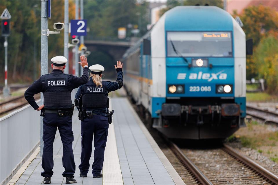 Bundespolizisten weisen per Handzeichen den Lokführer eines Zuges aus Prag in Richtung München darauf hin, dass sie zur Kontrolle des Einreiseverkehrs zusteigen werden. (Archivbild)Daniel Karmann/dpa