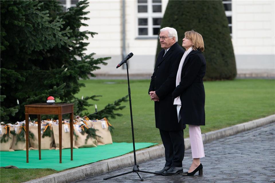 Bundespräsident Frank-Walter Steinmeier (l) und seine Frau Elke Büdenbender schalten die Beleuchtung des Weihnachtsbaums vor dem Schloss Bellevue ein. Markus Lenhardt/dpa