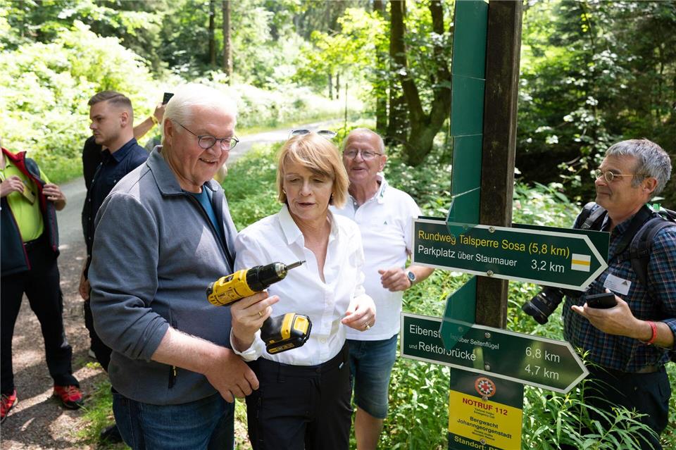 Bundespräsident Frank-Walter Steinmeier (links) gilt als leidenschaftlicher Wanderfan und half in Eibenstock bei der Beschilderung eines Weges. Sebastian Kahnert/dpa