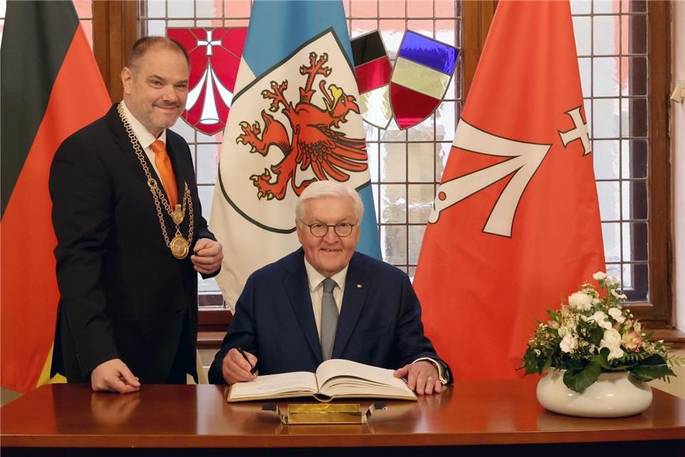 Bundespräsident Frank-Walter Steinmeier trägt sich ins Goldene Buch der Stadt Stralsund ein. Links im Bild: Stralsunds Oberbürgermeister Alexander Badrow (CDU)Bernd Wüstneck/dpa