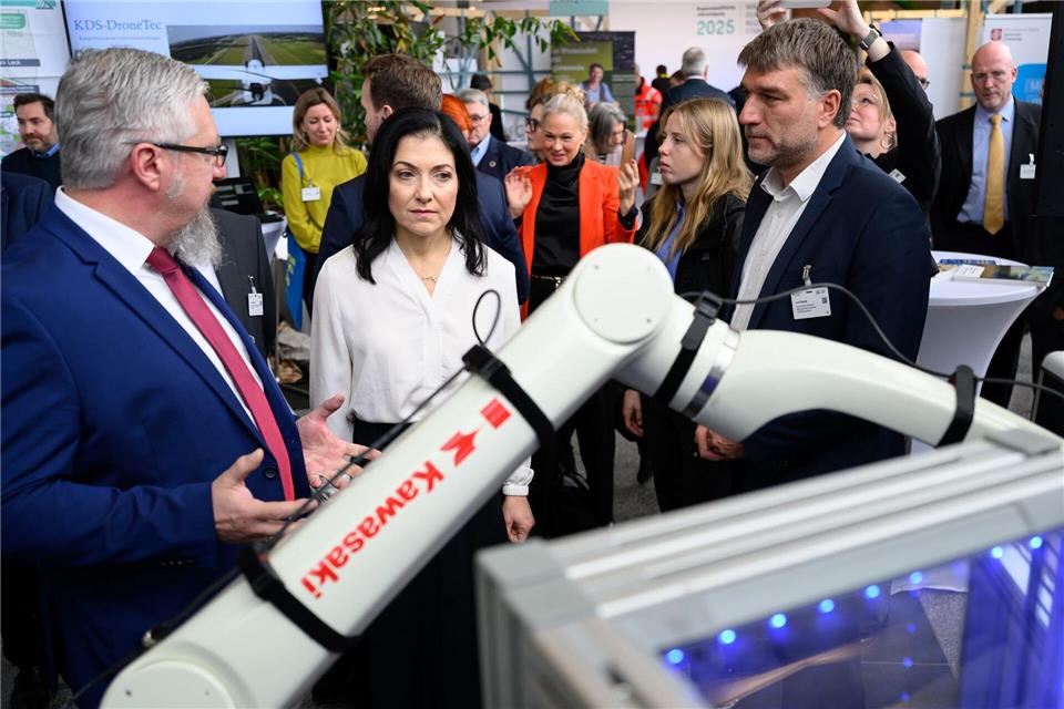 Bundeswirtschaftsministerin Katherina Reiche (Mitte l, CDU) am Stand des Innovationsclusters „Robotics Saxony“ mit Andreas Schneider (l) und Lars Georgi in Chemnitz. Hendrik Schmidt/dpa
