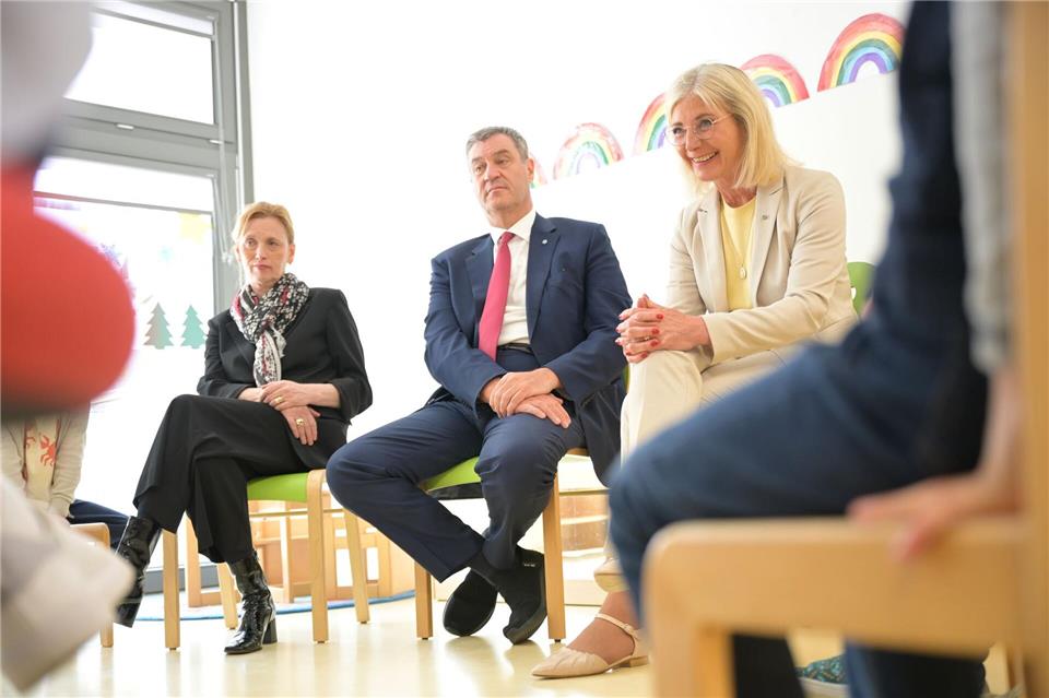 Bunte Regenbögen an der Wand und ein Stuhlkreis: In dieser Umgebung stellen sich Karin Prien, Markus Söder und Ulrike Scharf den Fragen von Vorschulkindern.Malin Wunderlich/dpa