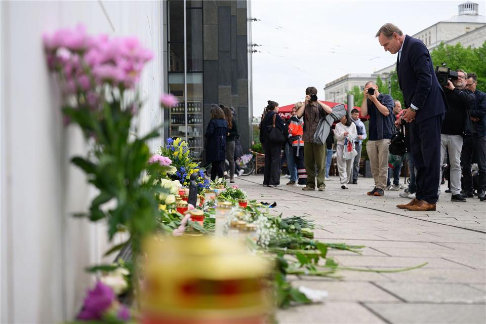 Burkhard Jung (SPD, r), Oberbürgermeister der Stadt Leipzig, verneigt sich nach der Amokfahrt mit zwei Todesopfern und drei Schwerverletzten am Gedenkort vor dem Paulinum der Universität. Hendrik Schmidt/dpa