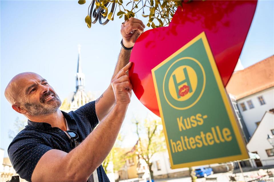 Café-Betreiber Jost Samorski will mit seiner „Kusshaltestelle“ in Eisenberg Passanten zum Küssen animieren. Jacob Schröter/dpa