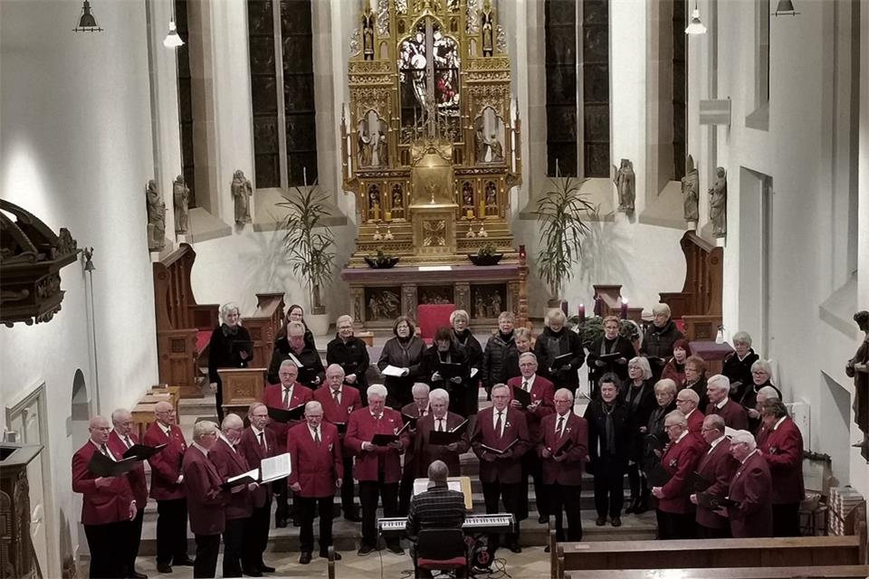 Chorleiter Albert Göken inmitten von Frauen und Männern der drei mitmachenden Chöre.