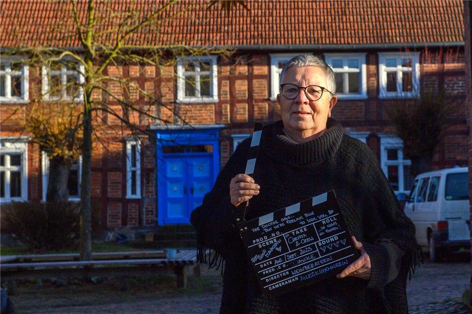 Christa Ringkamp steht mit einer Filmklappe in der Zufahrt zu ihrem Landhof Neulingen. Klaus-Dietmar Gabbert/dpa