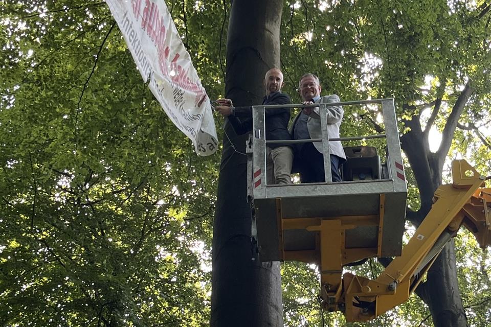 Christian Große Kreul, der Vorstandsvorsitzende der Korte-Stiftung, und Bürgermeister Martin Tesing entfernen eines der Plakate, die die „Querdenker“ im Tiergarten aufgehängt hatten.