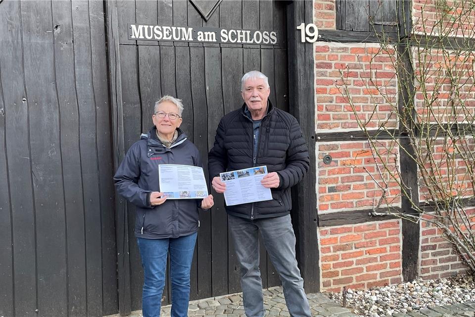 Christiane Danblon und Hans Brune präsentieren das Jahresprogramm des Heimatvereins vor dem Museum am Schloss.