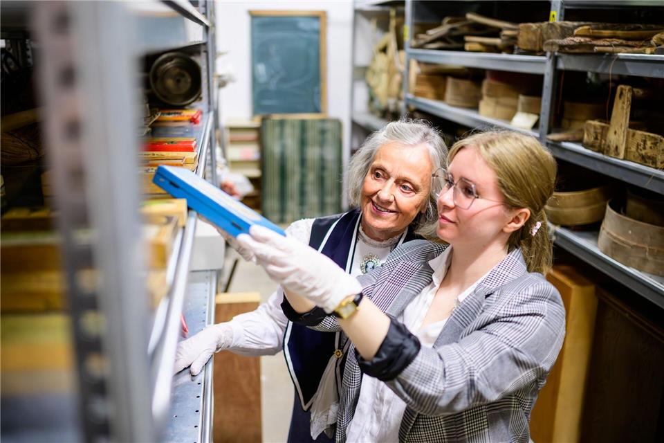 Christine Strüfing (l), ehemalige Lehrerin, und Lea Finzel, Kuratorin, schauen sich im Kiekeberg-Museum verschiedene Exponate an. Christine Strüfing trug tausende Objekte aus der Schule zusammen.Philipp Schulze/dpa