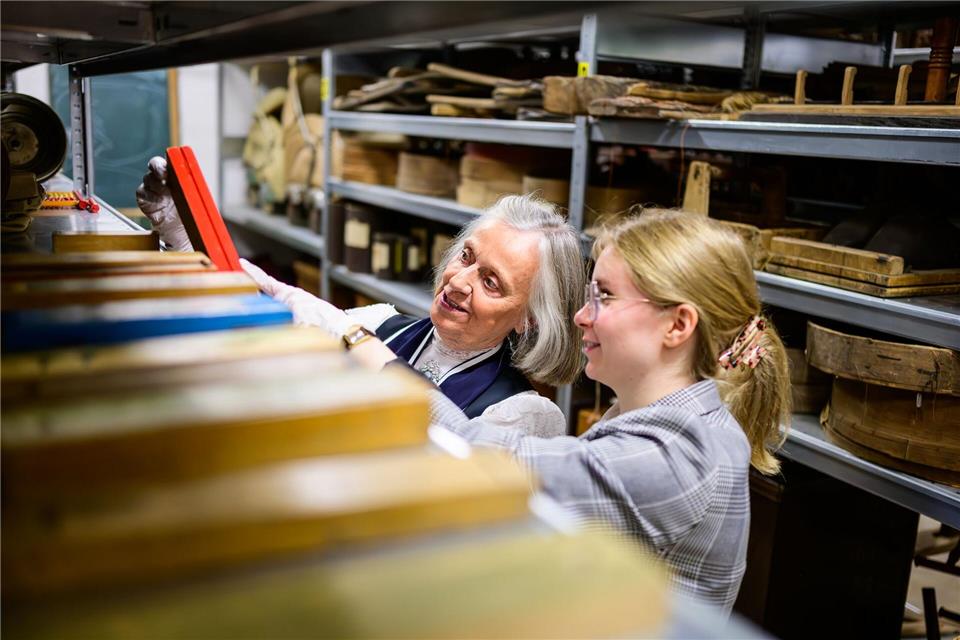 Christine Strüfing (l), ehemalige Lehrerin, und Lea Finzel, Kuratorin, schauen sich im Kiekeberg-Museum verschiedene Exponate an. Christine Strüfing trug tausende Objekte zusammen, die einen Zeitraum von mehr als 100 Jahren Schulgeschichte abdecken.Philipp Schulze/dpa
