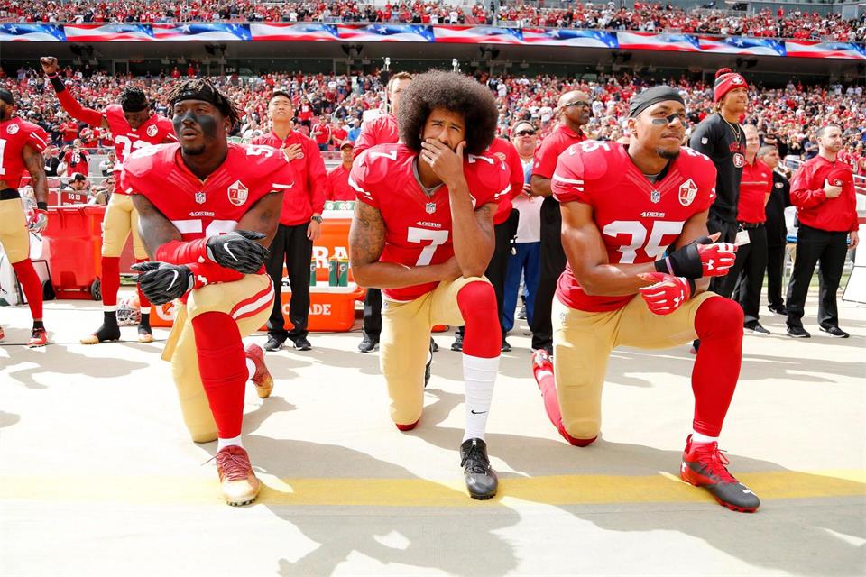 Colin Kaepernick (Mitte) kniend bei der Nationalhymne. Er bekam Unterstützung einiger Mitspieler, am Ende war es aber auch seine letzte Saison in der NFL. (Archivfoto)John G Mabanglo/EPA/dpa
