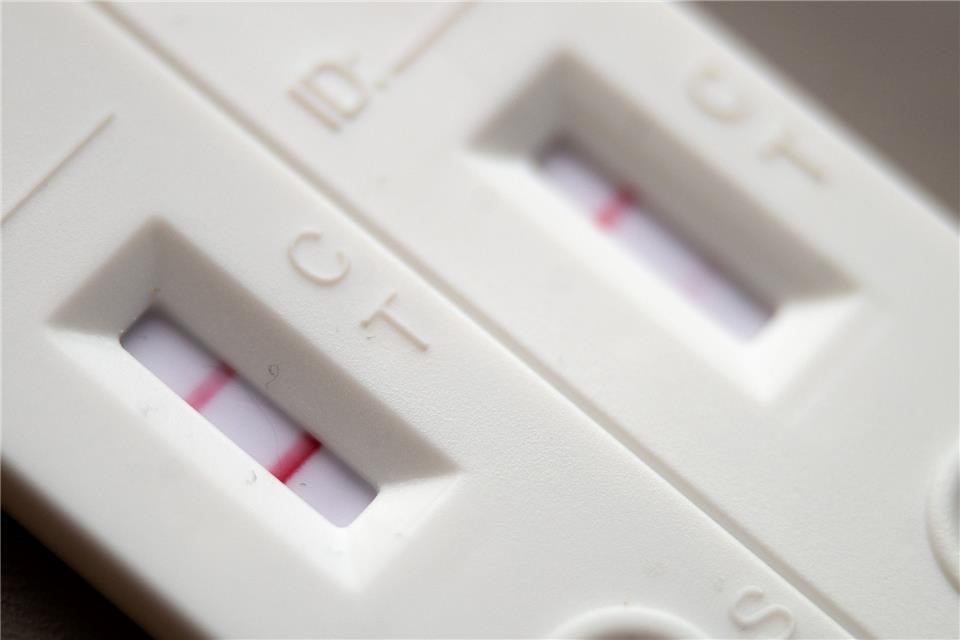 Corona-Schnelltests mit positivem (l) und negativem Ergebnis liegen auf einem Tisch.