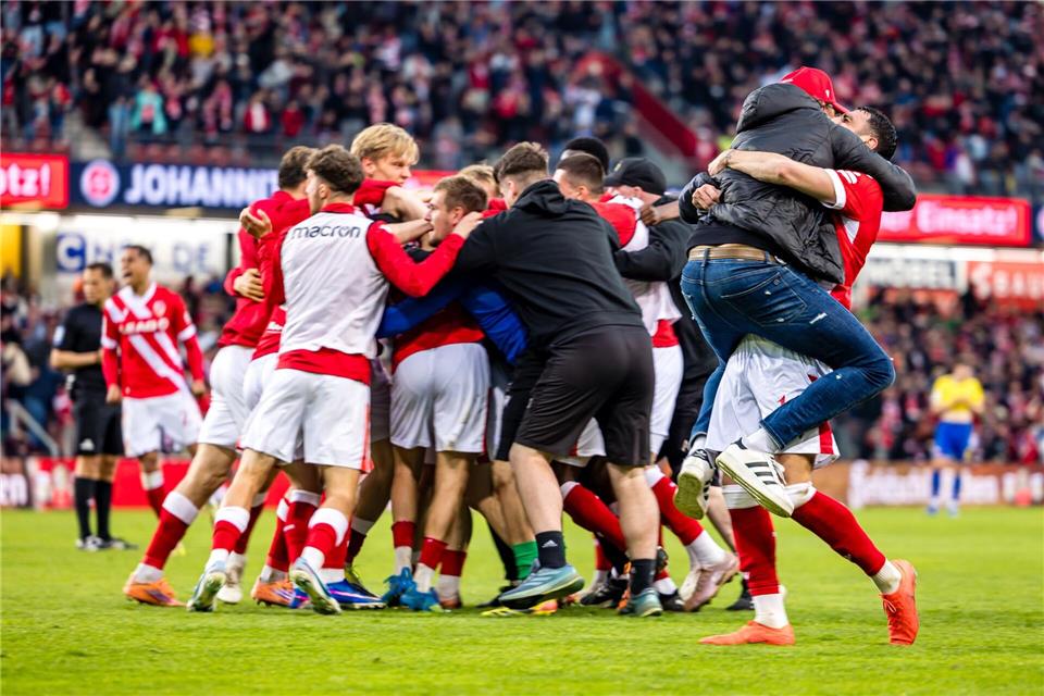 Cottbus im Jubel-Rausch: Trainer Claus-Dieter Wollitz springt seinem Dreifachtorschützen Tolcay Cigerci (r) in die Arme.Frank Hammerschmidt/dpa