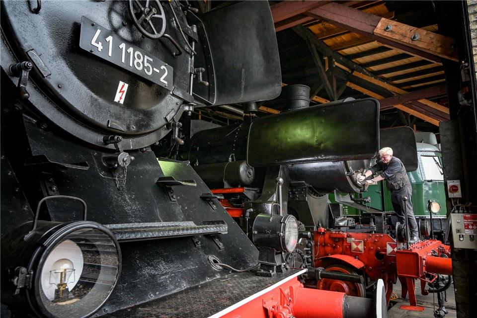 DB Museum Halle: Jörgen Seyffarth putzt eine Dampflok der Baureihe 52. Heiko Rebsch/dpa