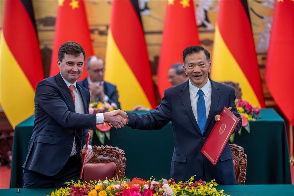 DFL-Geschäftsführer Steffen Merkel (l) und Shen Haixiong, Präsident der China Media Group CMG, nach der Unterzeichnung der Absichtserklärung.Michael Kappeler/dpa
