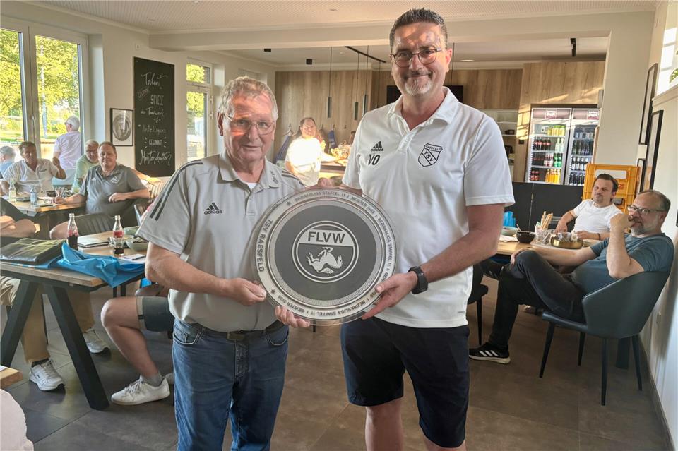 Da ist das Ding: Staffelleiter Horst Dastig (links) übergibt die Bezirksliga-Meisterschale an Volker Olbing, Fußball-Abteilungsleiter des TSV Raesfeld.