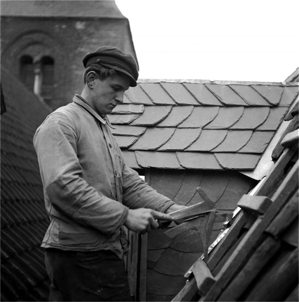 Dachdecker Wenning bei der Arbeit in luftiger Höhe.