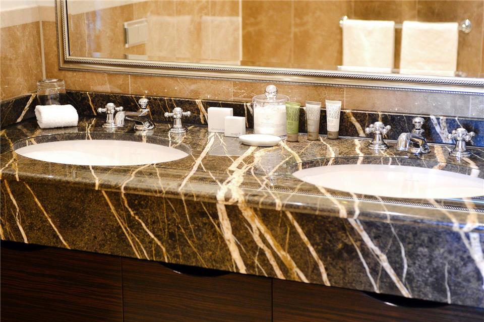 Damit keine unschönen Kalkflecken auf dem Marmor entstehen, wischt man die Oberfläche besser sofort trocken.Daniel Reinhardt/dpa/dpa-tmn