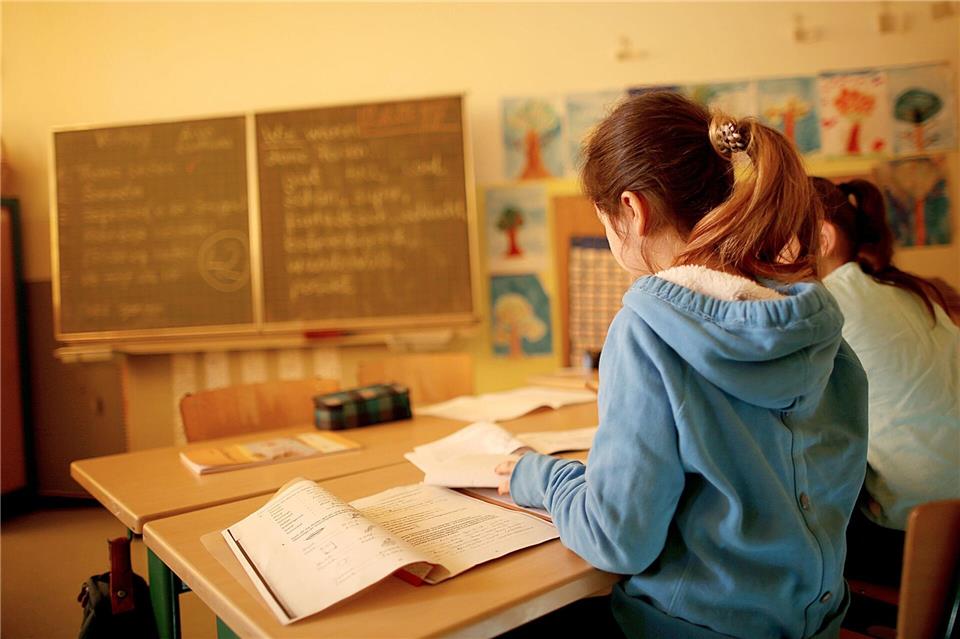 Damit sich links- und rechtshändige Schulkinder nicht mit den Ellenbogen ins Gehege kommen, sollte ein Linkshänder auf der linken Seite und der Rechtshänder auf der rechten Seite daneben sitzen.Oliver Berg/dpa/dpa-tmn