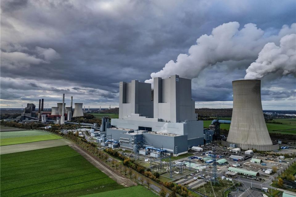 Dampf steigt aus dem RWE-Braunkohlekraftwerk Neurath. Das von RWE betriebene Kraftwerk gilt als das grüßte Braunkohlekraftwerk in Deutschland.