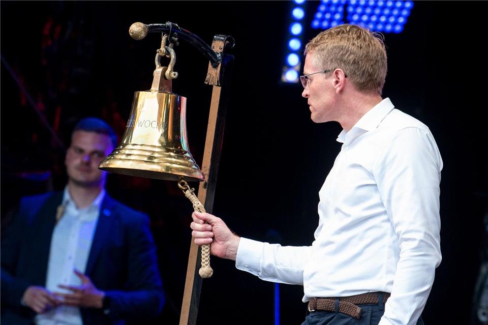 Daniel Günther (CDU), Ministerpräsident von Schleswig-Holstein, lässt zur offiziellen Eröffnung der Kieler Woche eine Schiffsglocke erklingen. Daniel Bockwoldt/dpa