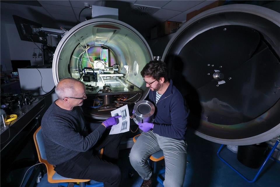 Daniel Spemann (links) und Lukas Pietzonka vom Leibniz-Institut für Oberflächenmodifizierung (IOM) bereiten einen Laborversuch mit einem Ionentriebwerk vor. Jan Woitas/dpa