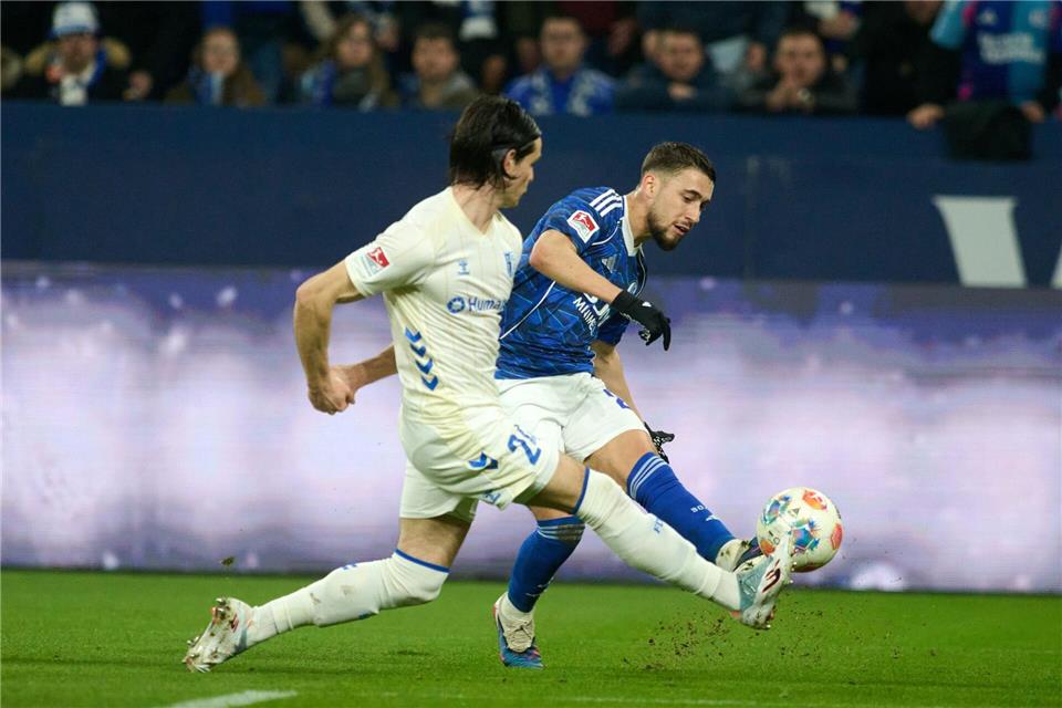 Das 1:0 für Schalke: Adil Aouchiche schießt, Magdeburgs Jean Hugonet fälscht mit der Fußspitze ab - und der Ball fliegt im hohen Bogen ins Tor. Bernd Thissen/dpa